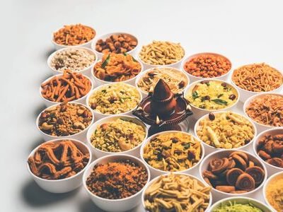 130719473-rangoli-of-farsan-snacks-in-bowls-for-diwali-with-diya